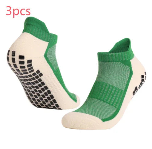 Pair of green and white non-slip ankle socks with black grip dots on soles
