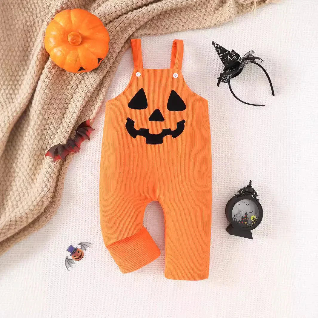 Orange baby Halloween romper with black jack-o-lantern face, pumpkin toy, bat decoration, witch hat headband