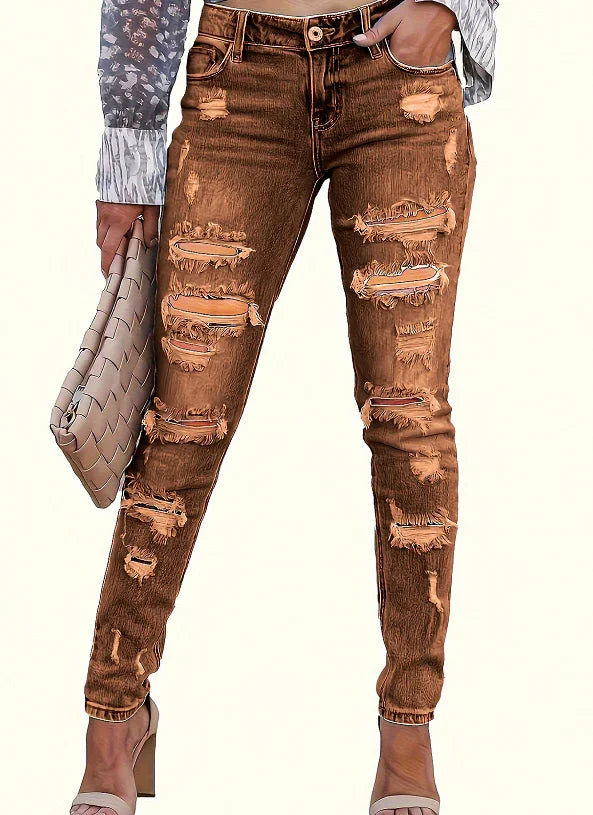 Woman wearing distressed brown skinny jeans with multiple rips, holding a beige clutch bag, paired with high heel sandals