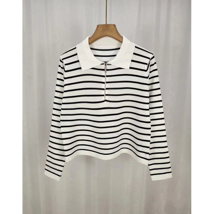 White long-sleeve knit top with black horizontal stripes and a white collar hanging on a wooden hanger