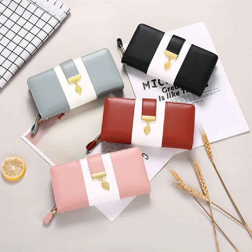 Four stylish leather wallets in pastel blue, black, brown, and pink with white accents and gold leaf charm