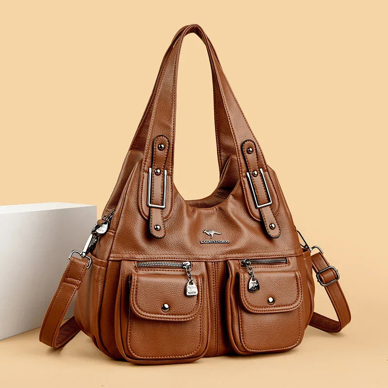 Brown leather shoulder handbag with multiple pockets and adjustable strap on beige background