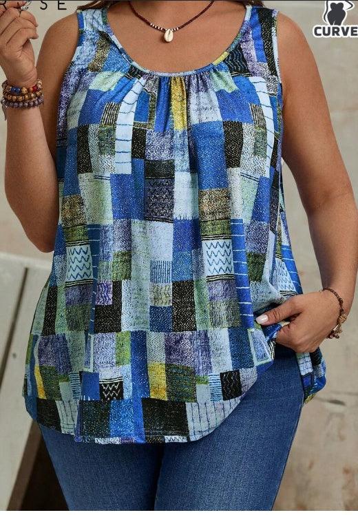 Woman wearing sleeveless blue patchwork patterned curved hem top paired with blue jeans