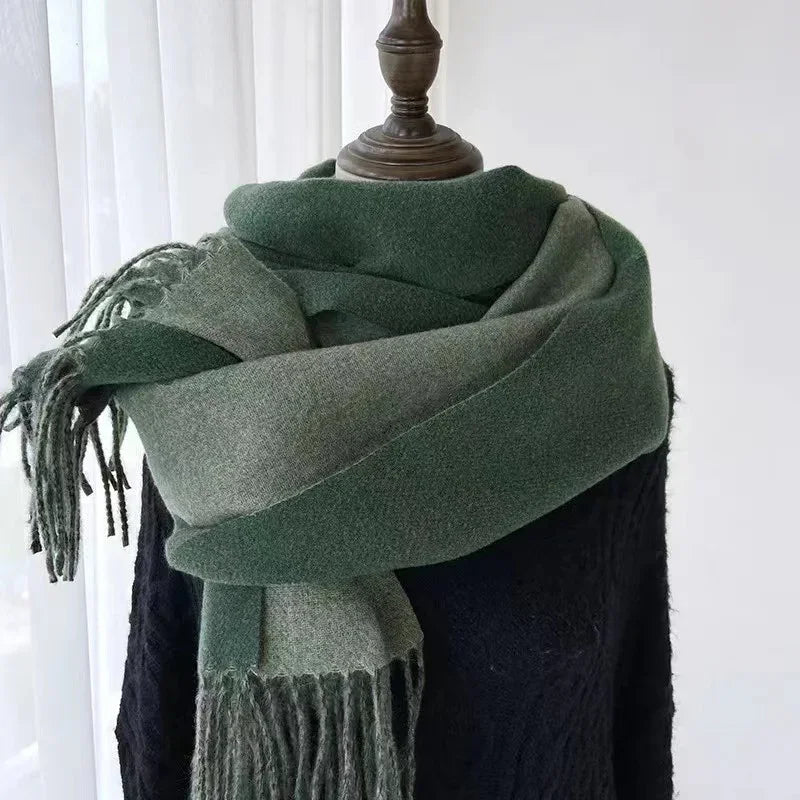Green and gray fringed wool scarf wrapped on a mannequin wearing a black sweater