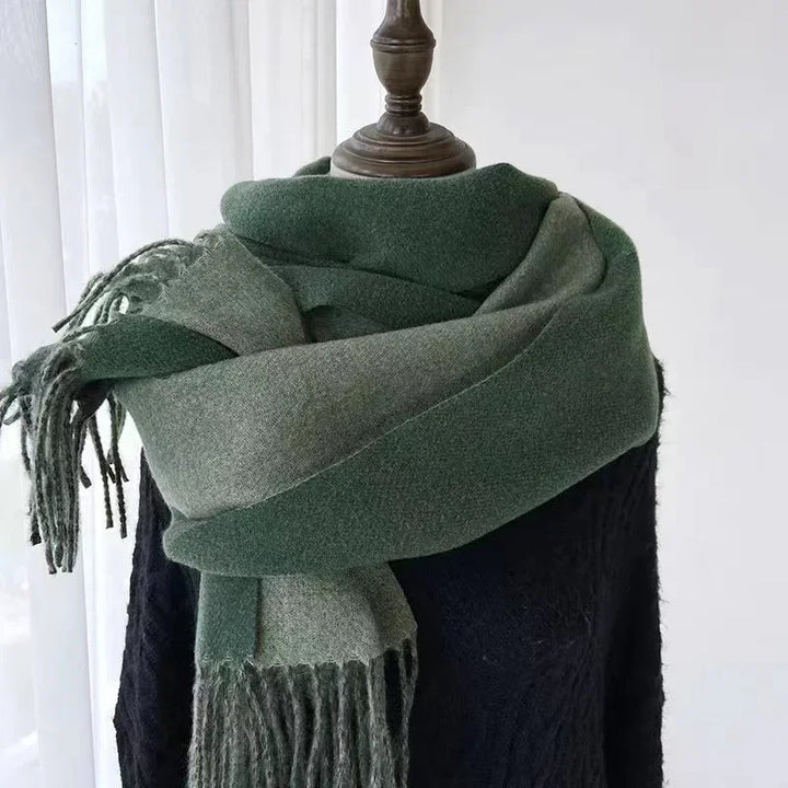 Green and gray fringed wool scarf wrapped on a mannequin wearing a black sweater