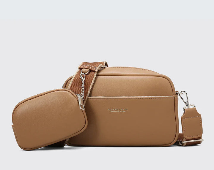 Tan leather crossbody bag and small pouch with adjustable strap against gray background