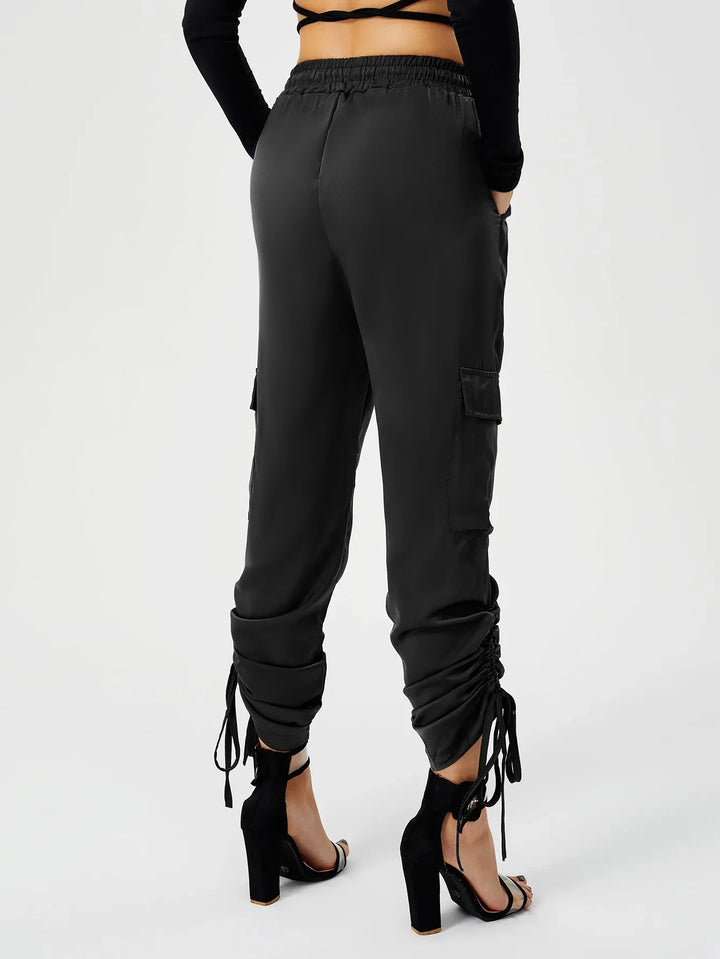 Back view of woman wearing black ruched cargo pants with high waist and black high heel sandals