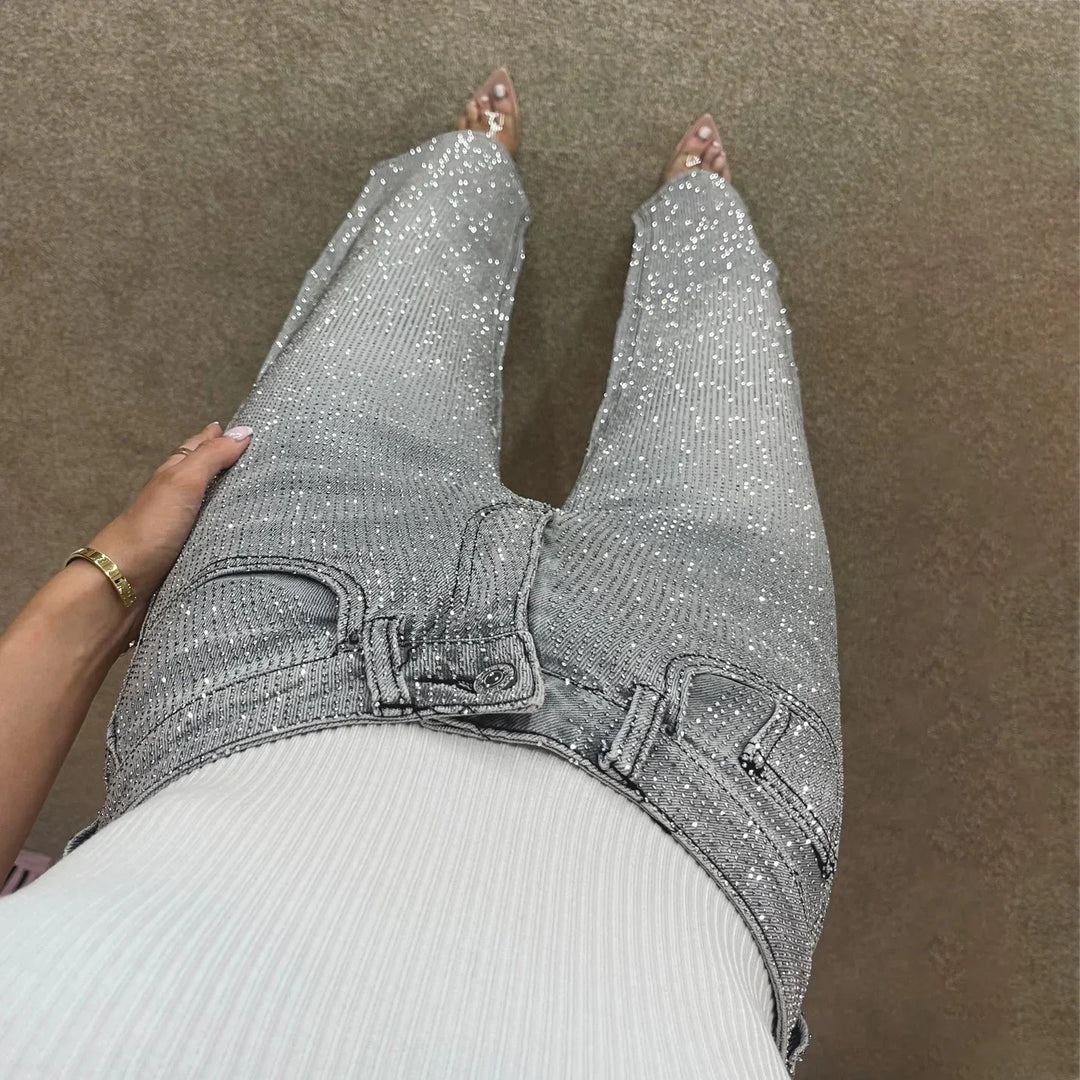 Woman wearing high-waisted silver sequin jeans with white ribbed top and clear heels