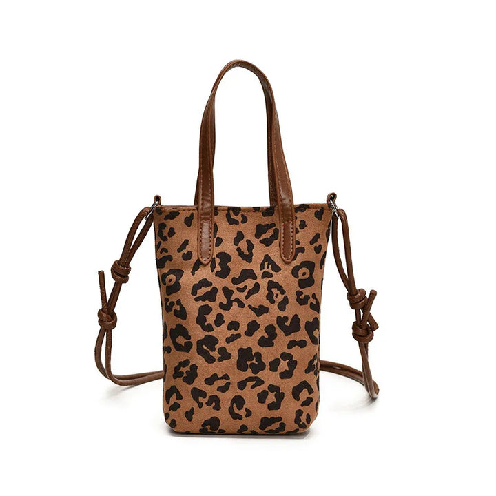 Brown leather tote bag with black leopard print and adjustable straps on white background