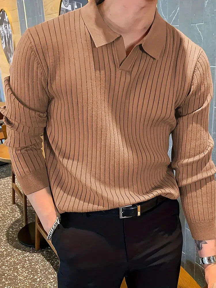 Man wearing a brown ribbed long-sleeve polo sweater with black pants and a black belt, indoors