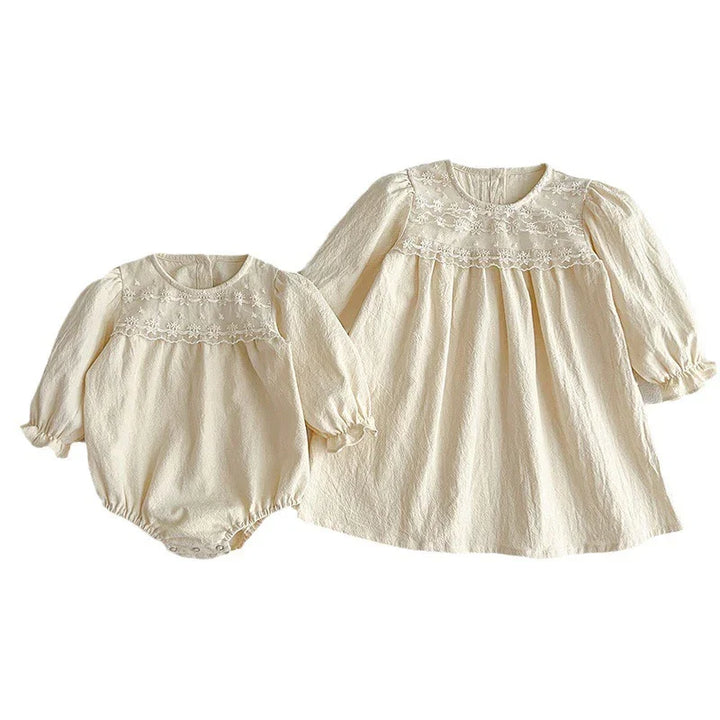 Cream-colored baby romper and long sleeve dress with embroidered floral lace yoke