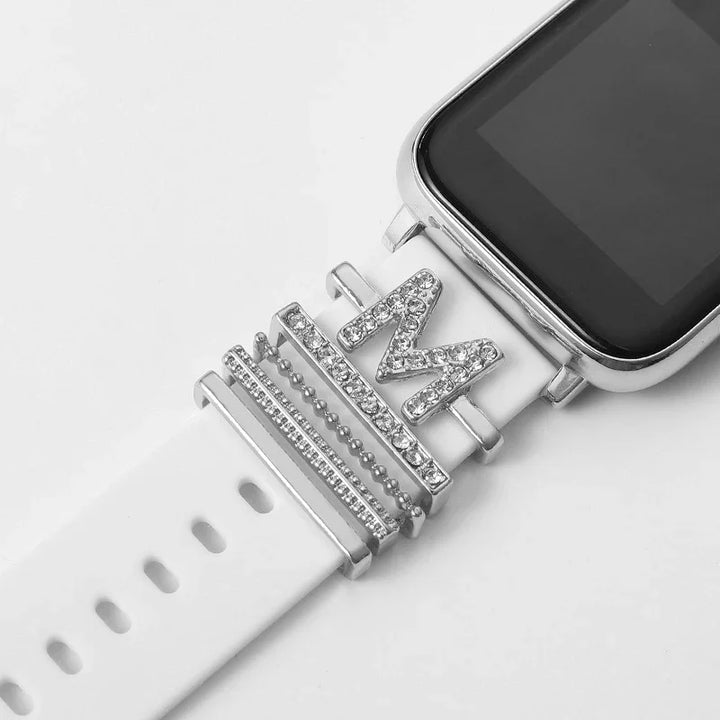 White smartwatch band with silver and rhinestone decorative charms including a letter M