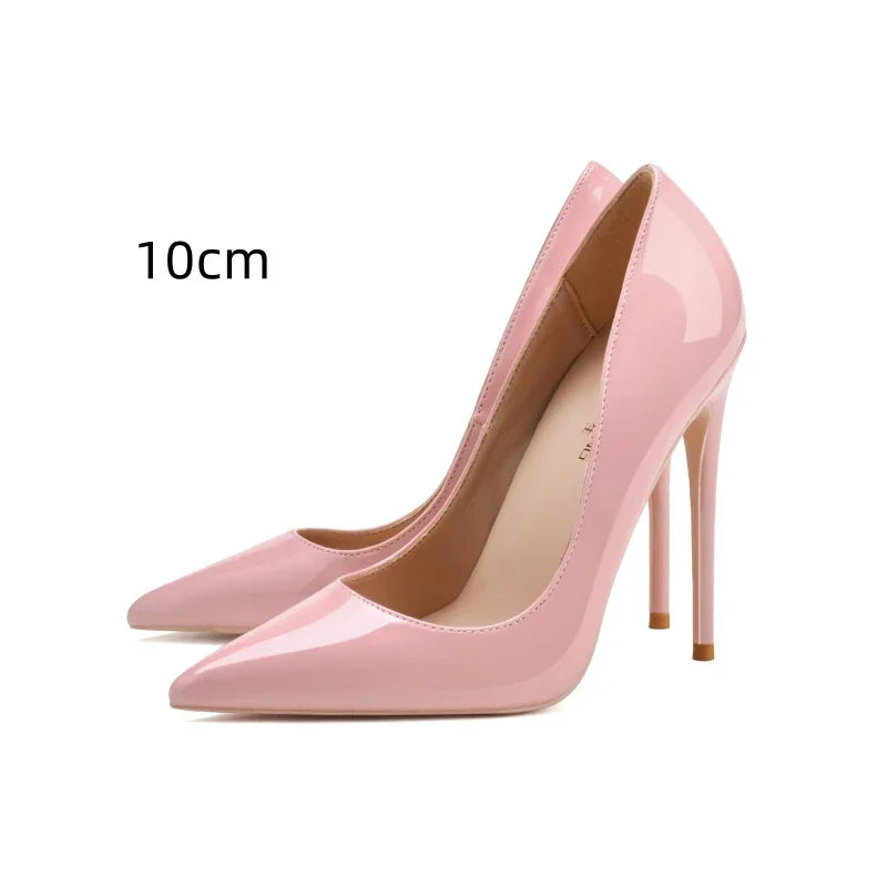 Pair of glossy pink patent leather high heels with 10cm stiletto heels on white background