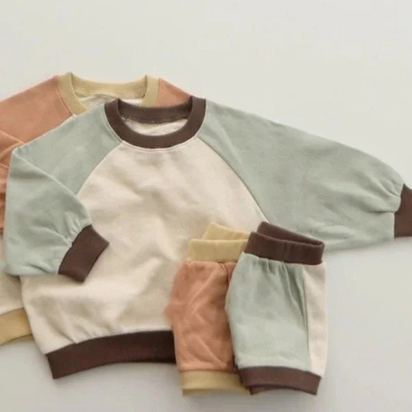 Two soft cotton toddler sweatshirts and matching pants in pastel blue, beige, brown, and peach colors