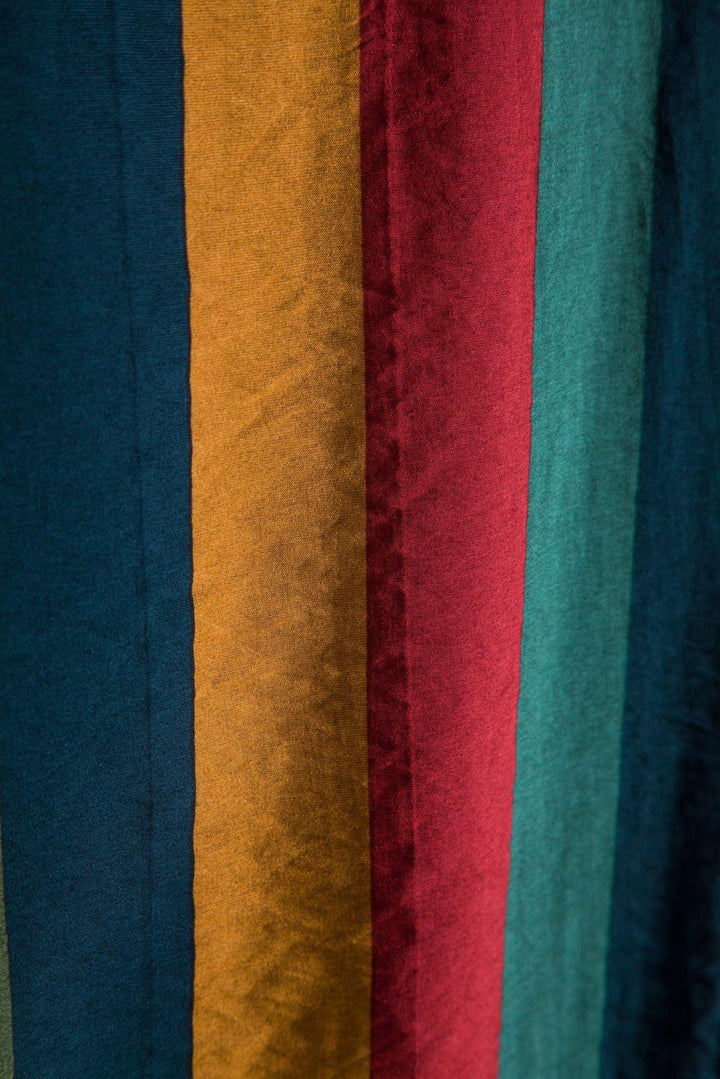 Close-up of vertical soft fabric stripes in teal, mustard, red, and green colors