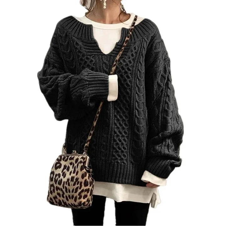Woman wearing black cable knit sweater over white shirt with leopard print crossbody bag