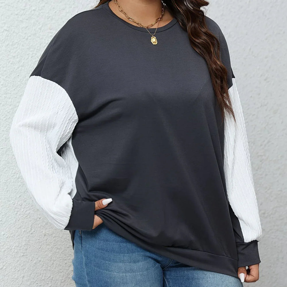 Plus size woman wearing black and white long sleeve casual top with blue jeans