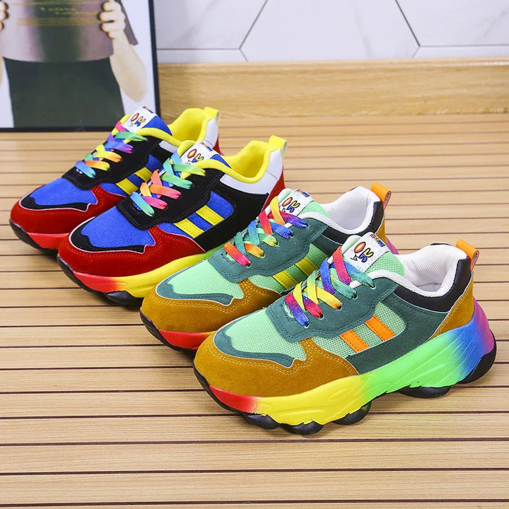 Colorful chunky sneakers with rainbow laces and multicolor soles displayed on wooden floor