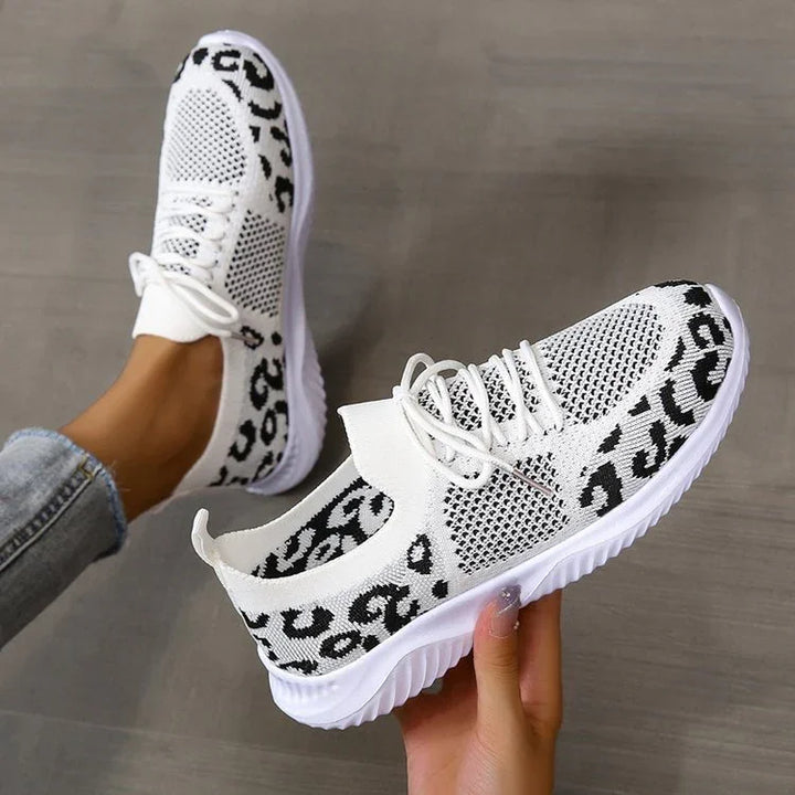 White lightweight sneakers with black leopard print and breathable mesh, styled with jeans