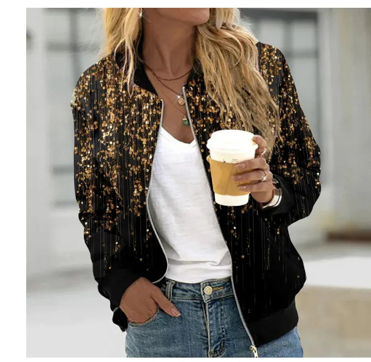 Woman wearing black bomber jacket with gold glitter pattern, white top, blue jeans, holding coffee cup