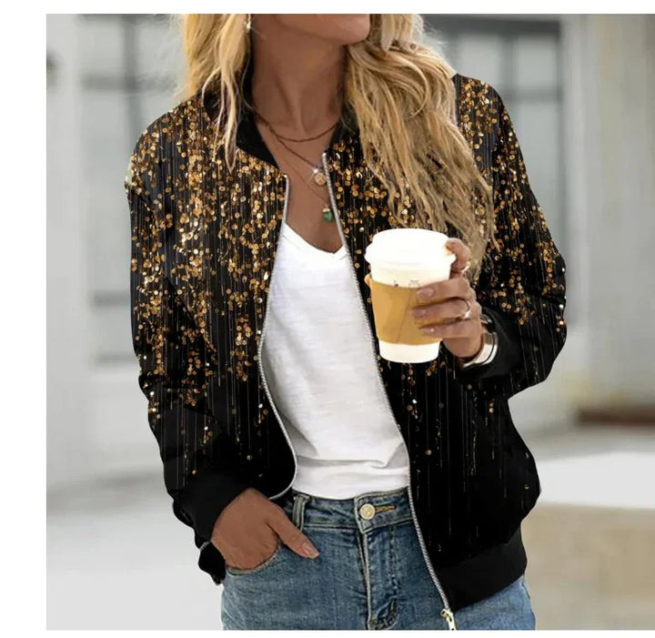 Woman wearing black bomber jacket with gold glitter pattern, white top, blue jeans, holding coffee cup