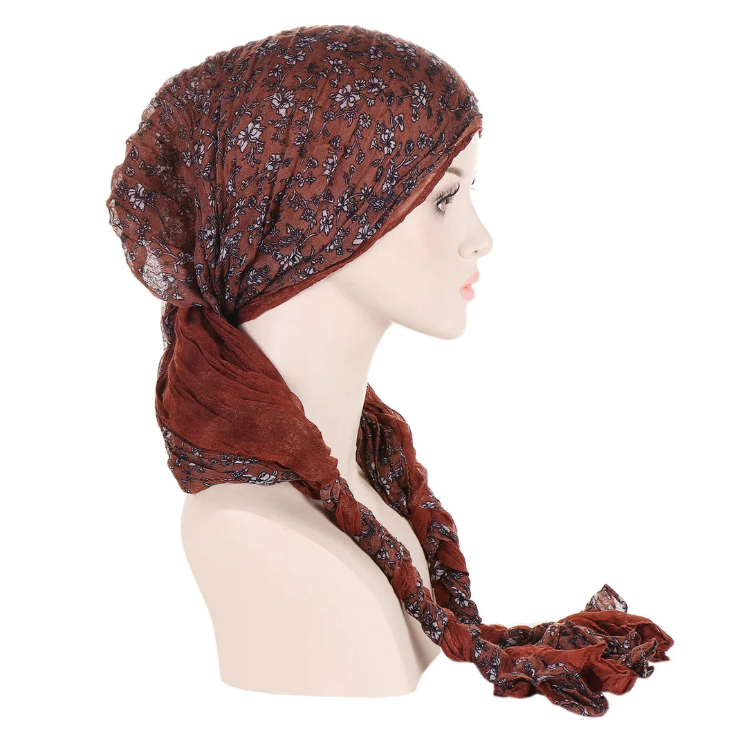 Side view of mannequin wearing brown floral headscarf with long tied ends