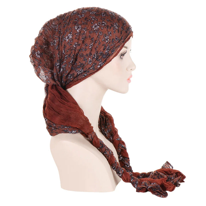 Side view of mannequin wearing brown floral headscarf with long tied ends