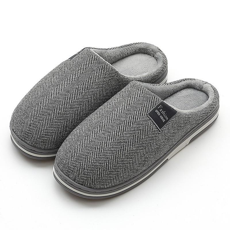 Gray herringbone pattern indoor slippers with soft lining and black label on a white background