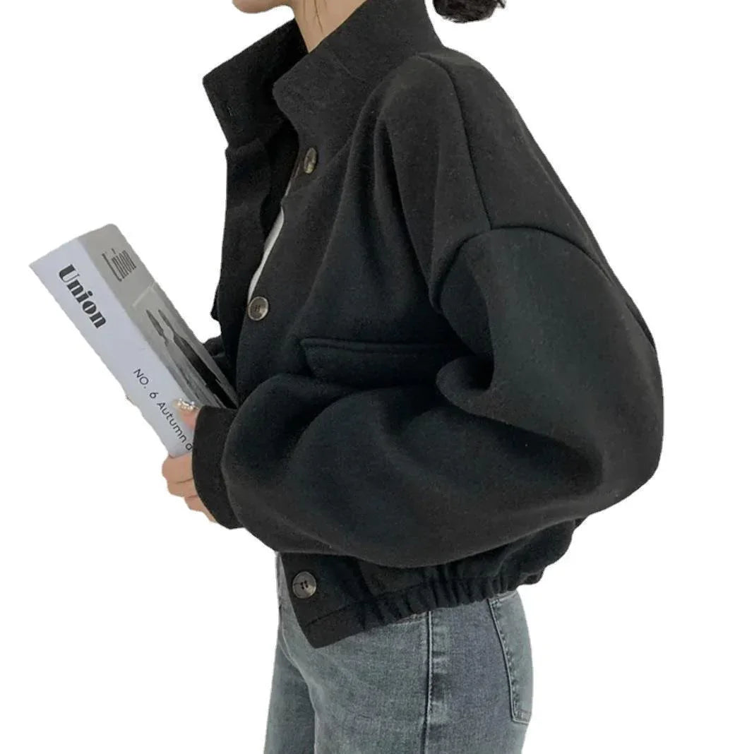 Woman wearing black button-up jacket with elastic waist and holding a magazine titled Union
