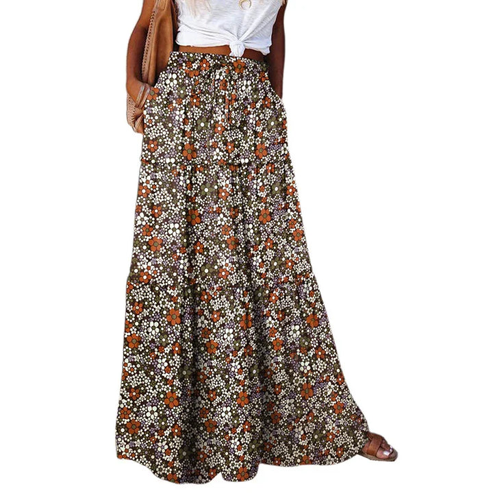 Woman wearing a high-waisted floral print maxi skirt with a tied white crop top and sandals