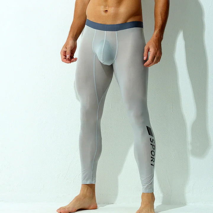 Man wearing light grey sport compression leggings with black SPORT logo on left leg
