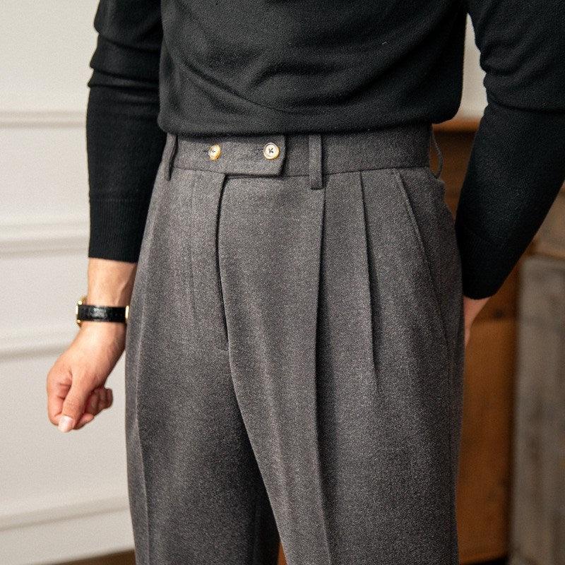 Man wearing high-waisted grey pleated trousers with button detail and black sweater