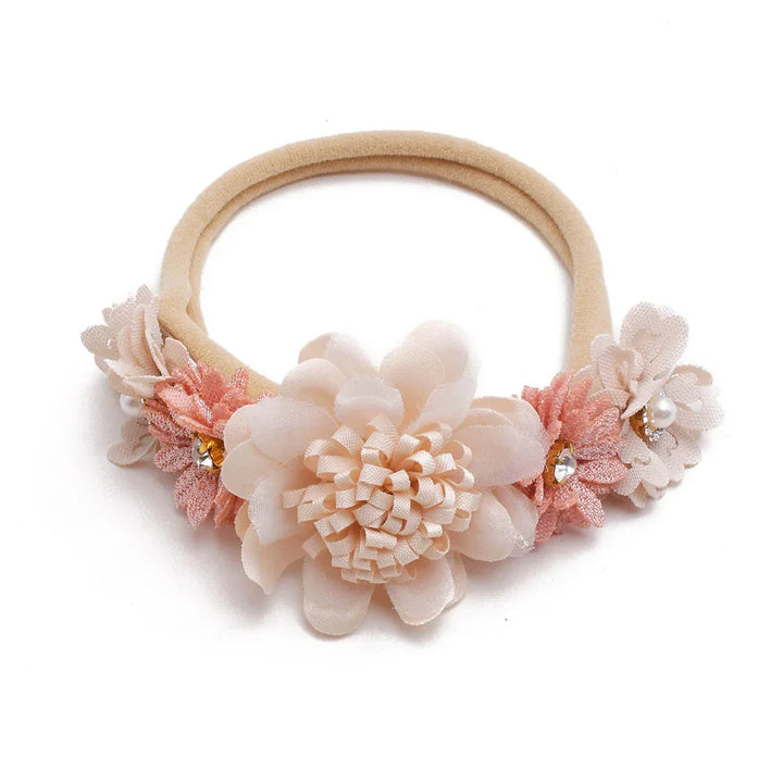 Beige baby headband with soft fabric flowers and rhinestone accents on white background