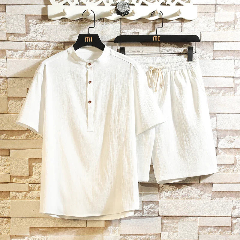 White casual men's summer outfit featuring a short-sleeve buttoned shirt and elastic-waist shorts on hangers