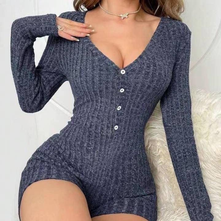 Woman wearing a fitted dark grey ribbed knit romper with long sleeves and buttons on front
