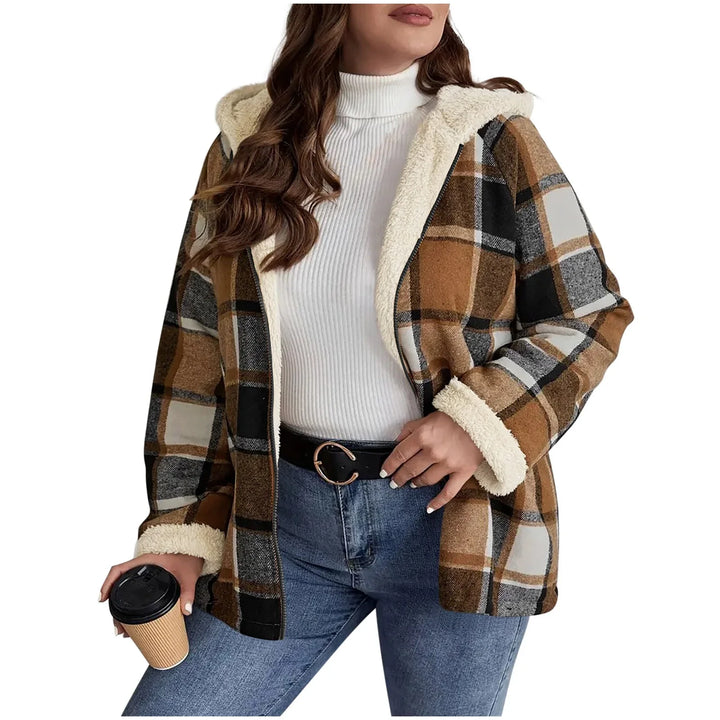 Woman wearing brown and gray plaid sherpa lined hooded jacket with white turtleneck and jeans holding coffee cup