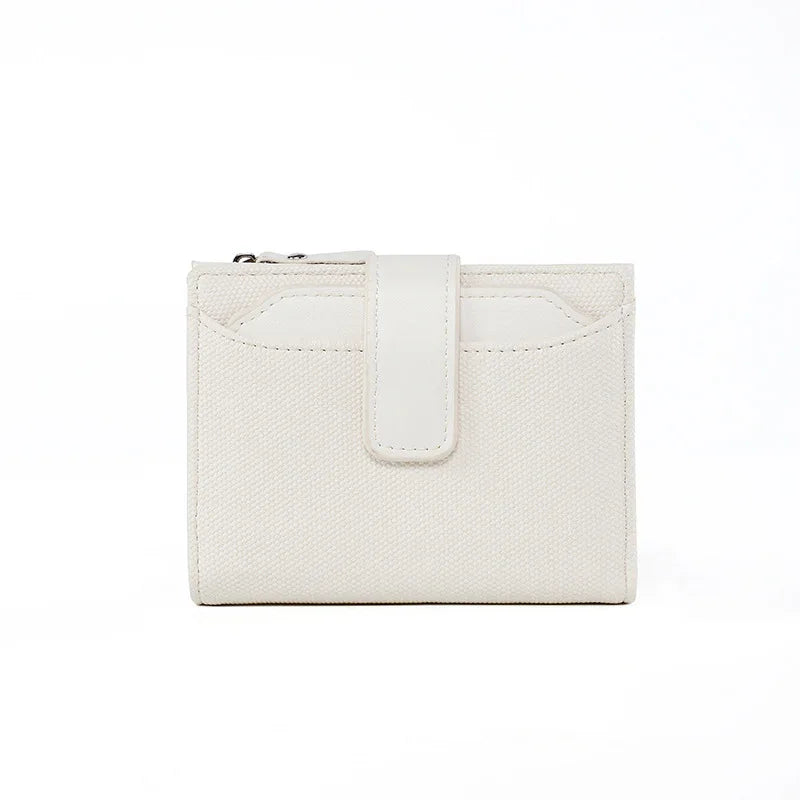 White textured fabric wallet with a front snap closure and card slots on white background