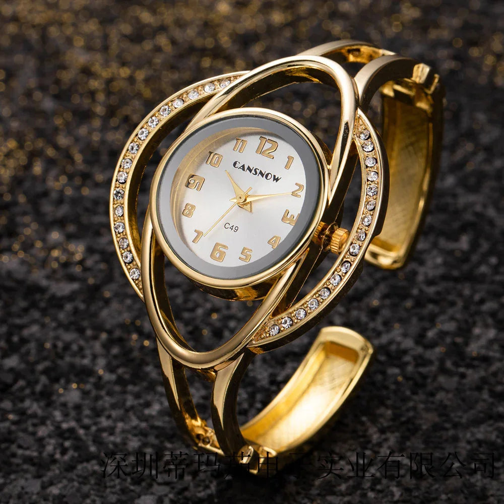 Elegant gold women's wristwatch with crystal accents on black textured background