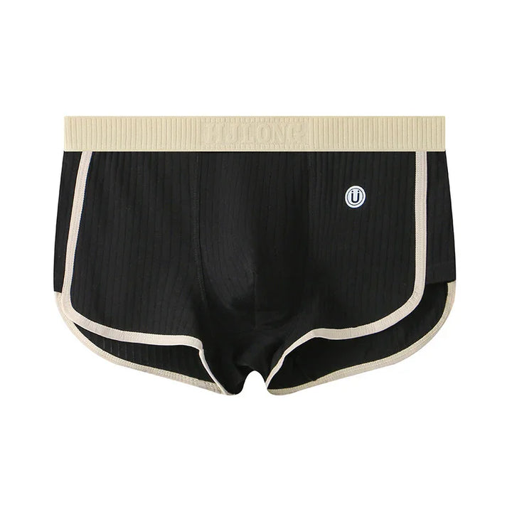 Black ribbed men's boxer briefs with beige waistband and trim, featuring a small circular logo