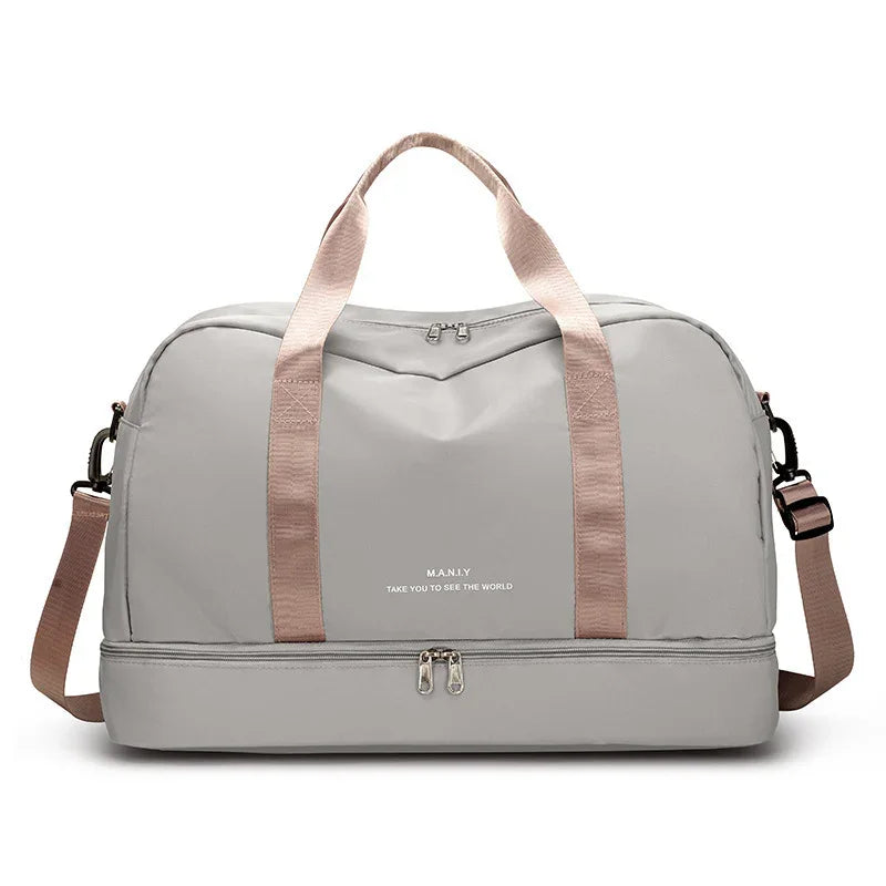 Light grey travel duffel bag with pink straps and separate bottom compartment