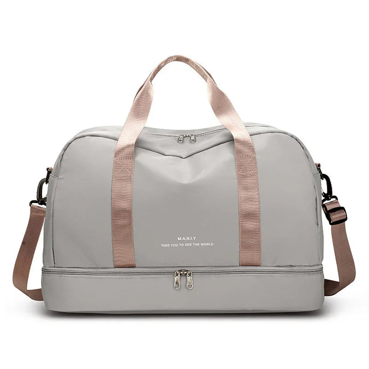 Light grey travel duffel bag with pink straps and separate bottom compartment