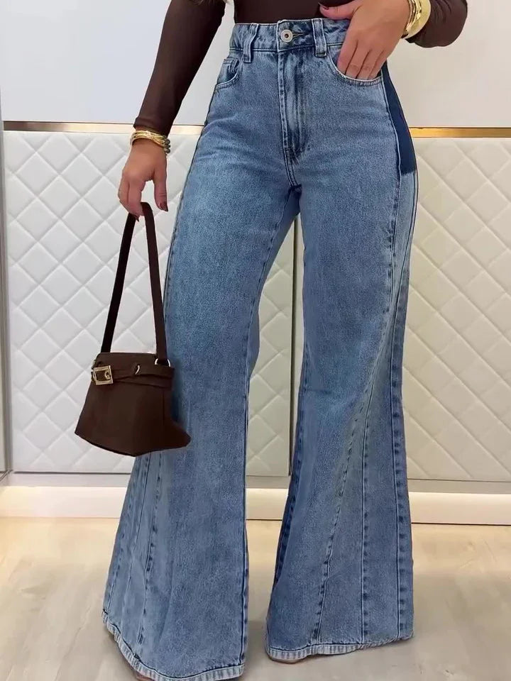 Woman wearing high-waisted light blue wide-leg jeans with dark side panels, holding brown handbag