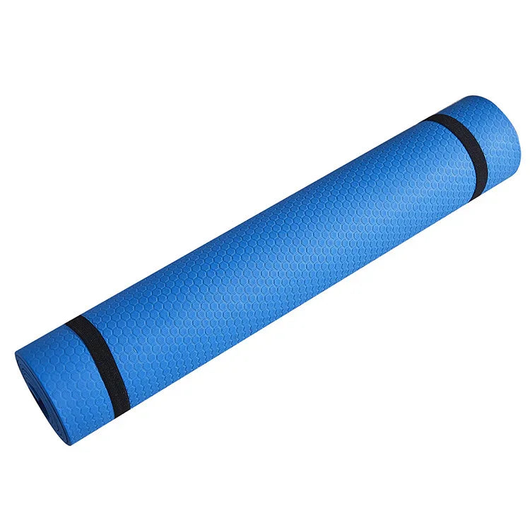 Rolled blue yoga mat with honeycomb texture and black straps on a white background