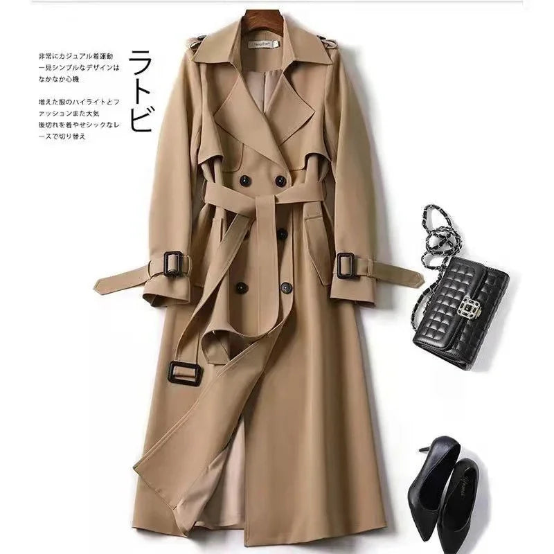 Beige double-breasted trench coat with belt, black quilted handbag, black pointed-toe heels on white background