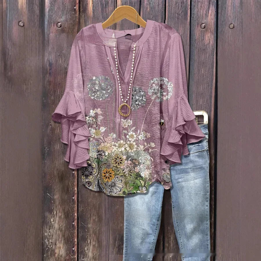 Lavender floral blouse with ruffled sleeves paired with light blue jeans on wooden background