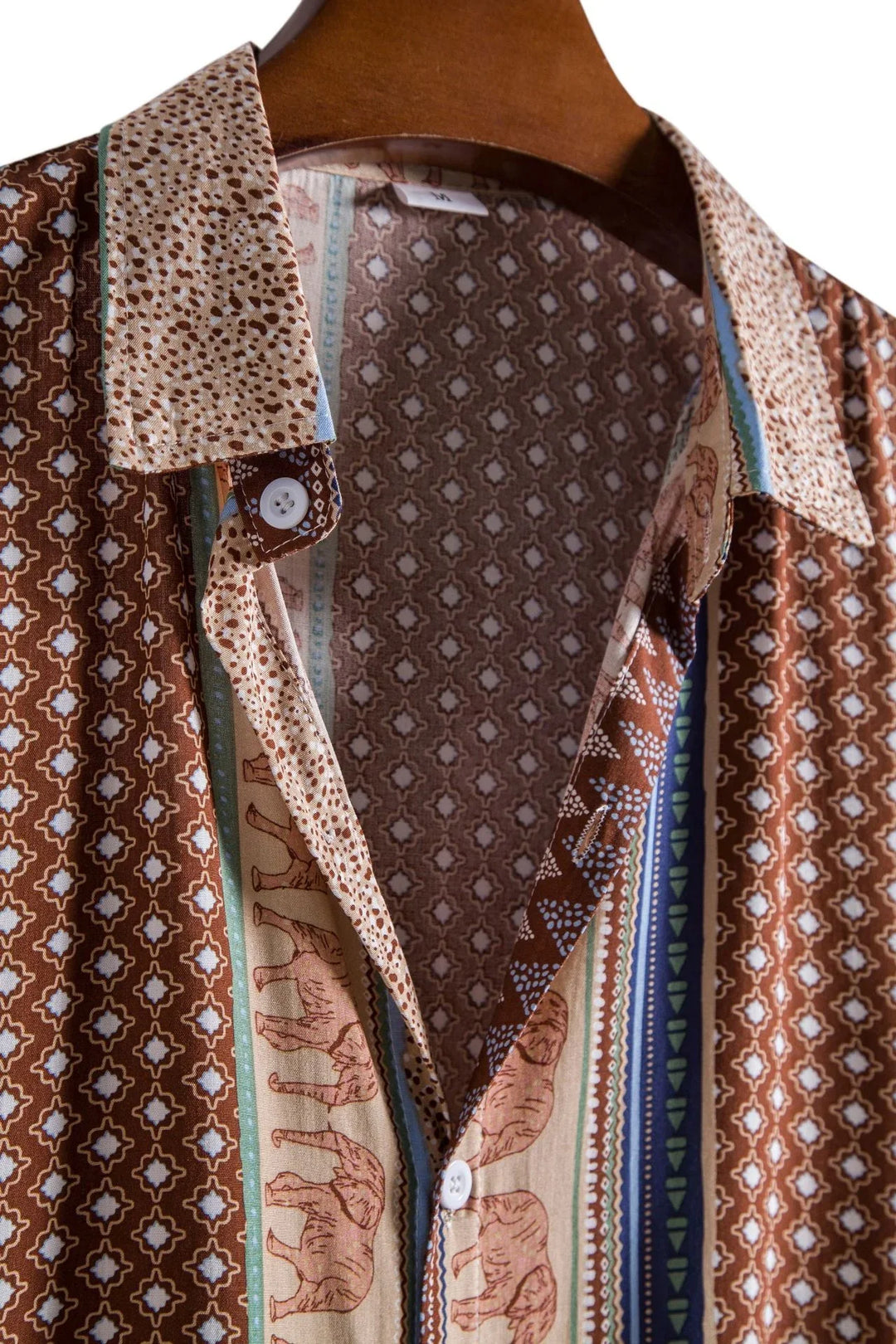 Vintage brown patterned shirt with elephant and geometric prints on wooden hanger