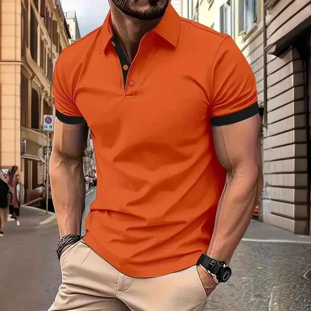 Man wearing a fitted orange polo shirt with black trim and beige pants in urban street setting