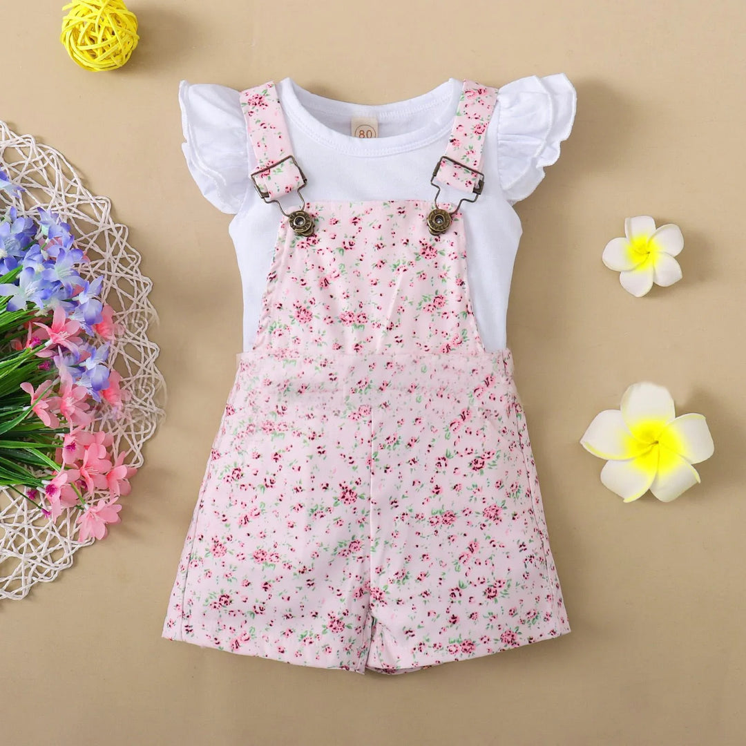 Baby girl floral pink overall shorts with white ruffle sleeve top on beige background with flowers