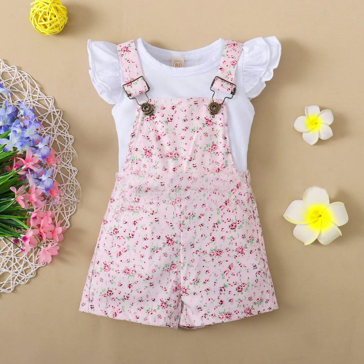 Baby girl floral pink overall shorts with white ruffle sleeve top on beige background with flowers