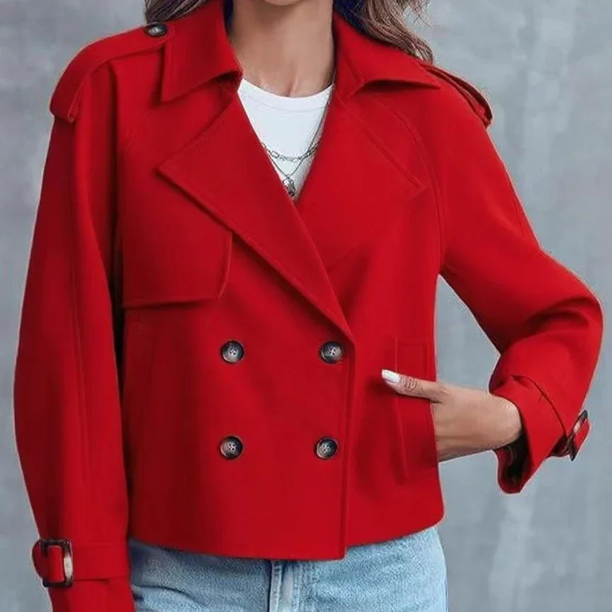 Woman wearing stylish red double-breasted coat with black buttons and buckled cuffs